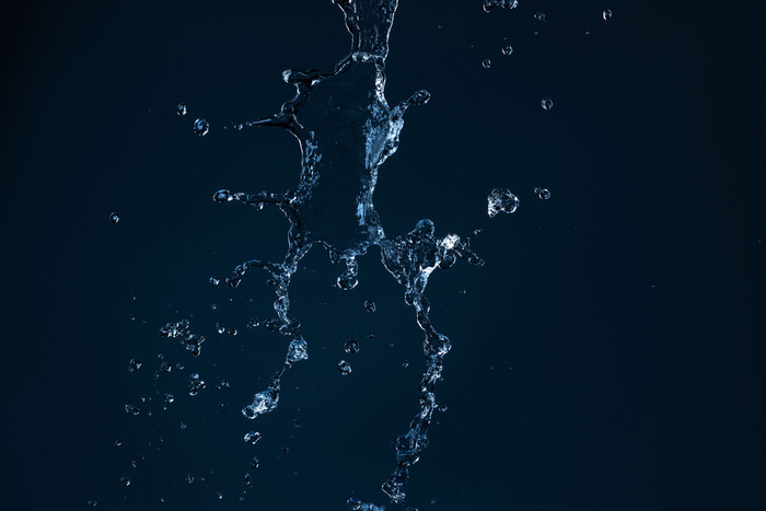干净的水射流落在空旷的黑色背景上