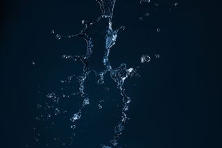 干净的水射流落在空旷的黑色背景上