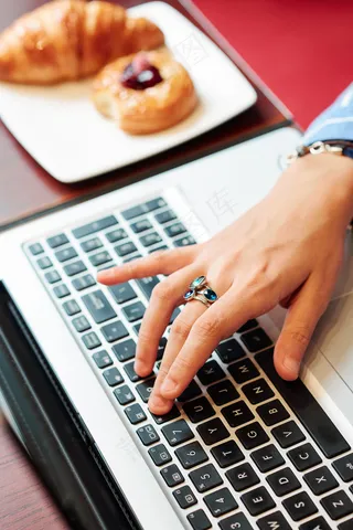 在笔记本电脑上工作的女人之手