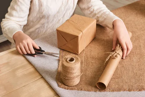 重点关注女士手上白色针织毛衣包装箱。手工包装纸和天然绳线。节日礼物快乐,惊喜。礼礼日礼物 重点关注女士手上白色针织毛衣包装箱。手工包装纸和天然绳线。节日礼物快乐,惊喜。礼礼日礼物