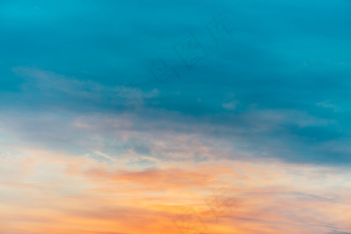 夕阳的天空有橙黄色的轻云。五颜六色平滑的蓝天渐变。日出的自然背景。清晨的天堂。傍晚有点多云。黎明时天气真好。