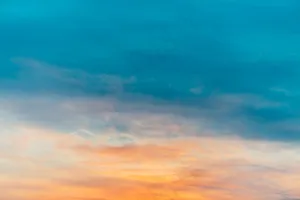 夕阳的天空有橙黄色的轻云。五颜六色平滑的蓝天渐变。日出的自然背景。清晨的天堂。傍晚有点多云。黎明时天气真好。