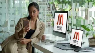 女企业家使用带有桌面模型样机的智能手机的肖像