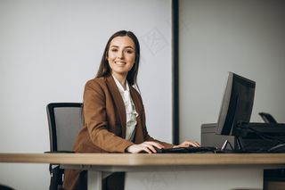 在办公室用笔记本电脑工作的年轻女商人