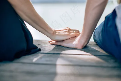 一对年轻夫妇手牵手的特写照片。爱的概念,家庭和亲密。 一对年轻夫妇手牵手的特写照片。爱的概念,家庭和亲密。