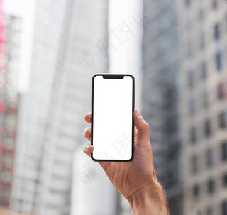 城市街道上拿着智能手机的手