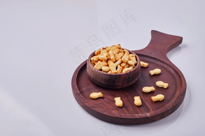 灰色背景下隔离的木杯里的咸饼干