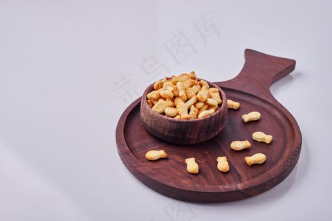 灰色背景下隔离的木杯里的咸饼干