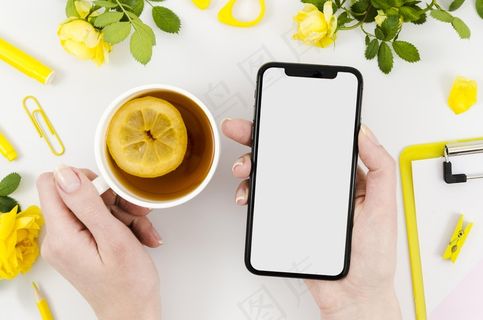 顶视图手拿智能手机模型样机与茶