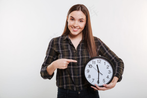 微笑着拿着钟的衬衫女人