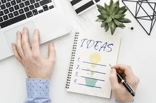 办公桌上的人在笔记本上写字