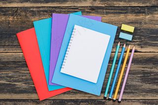 学校大流行概念后用笔记本、铅笔、书签贴纸平放在木制桌子上。