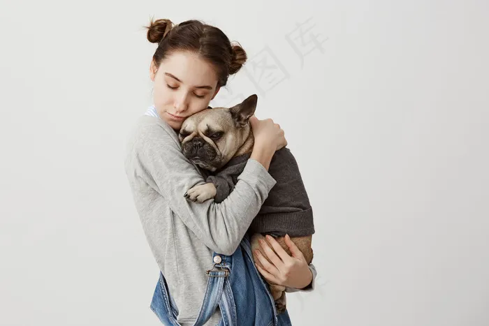 白人妇女的头像，闭着眼睛抱着她可爱的宠物般的孩子在一起放松。可爱女孩抱着穿毛衣的小狗的温柔情感。关心，爱的概念