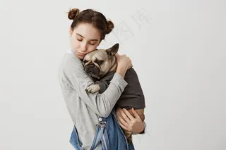 白人妇女的头像，闭着眼睛抱着她可爱的宠物般的孩子在一起放松。可爱女孩抱着穿毛衣的小狗的温柔情感。关心，爱的概念