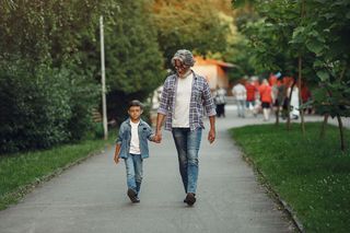 男孩和爷爷正在公园里散步。和孙子玩耍的老人。