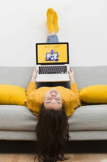 女性坐在沙发上用笔记本电脑工作