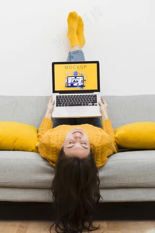 女性坐在沙发上用笔记本电脑工作