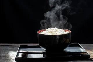 黑底黑碗蒸米饭，热腾腾的米饭在碗里选择性聚焦，热食健康