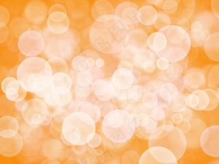 橙色背景上的抽象白色(bokeh)散景