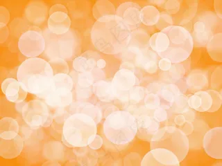 橙色背景上的抽象白色(bokeh)散景
