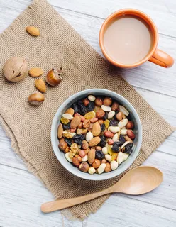 麻布上的一杯茶混合坚果和干果的俯视图 麻布上的一杯茶混合坚果和干果的俯视图