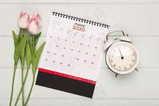 日历和时钟旁的郁金香花束