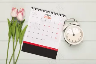 日历和时钟旁的郁金香花束