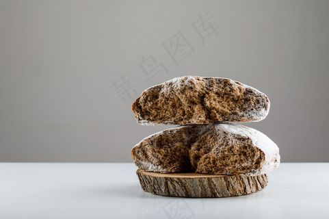 在白色桌子和灰色表面的木头上的侧视蛋糕。水平，文本空格