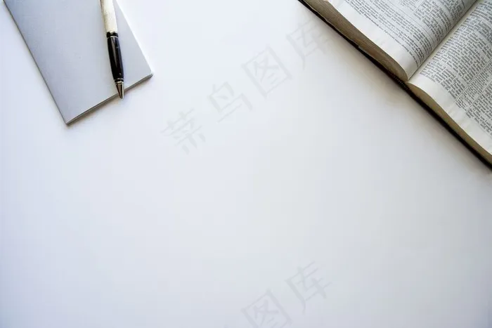 一本打开的圣经和一个白色表面上有笔的记事本