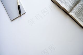 一本打开的圣经和一个白色表面上有笔的记事本