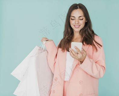 身穿粉红色夹克的黑发女人看着智能手机