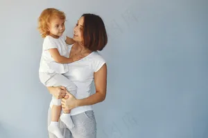 妈妈和小女儿在蓝色背景下玩得很开心