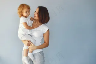 妈妈和小女儿在蓝色背景下玩得很开心