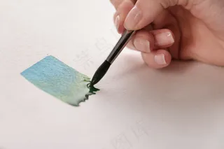 画家在白纸上用毛笔画出五颜六色的条纹