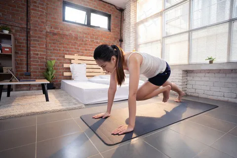 亚洲女性在家里做室内运动她扮演“登山者”