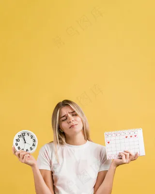 女人拿着时钟和月经日历复印空间