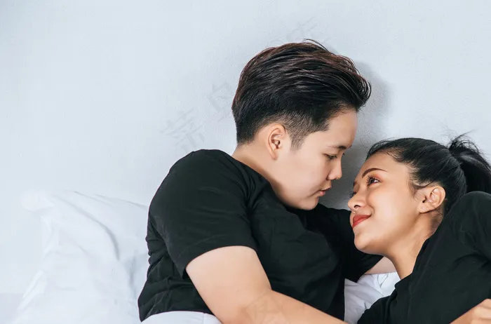 两对女伴依偎在床上。