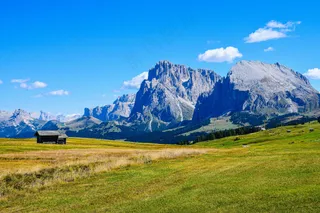 蓝天下的翠绿草原与雄伟山脉