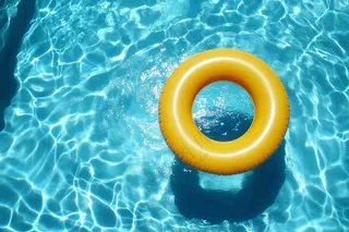 蓝色游泳池的黄色游泳圈摄影图