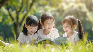 公园草坪看书阅读的学生孩子们知识兴趣世界读书日摄影图