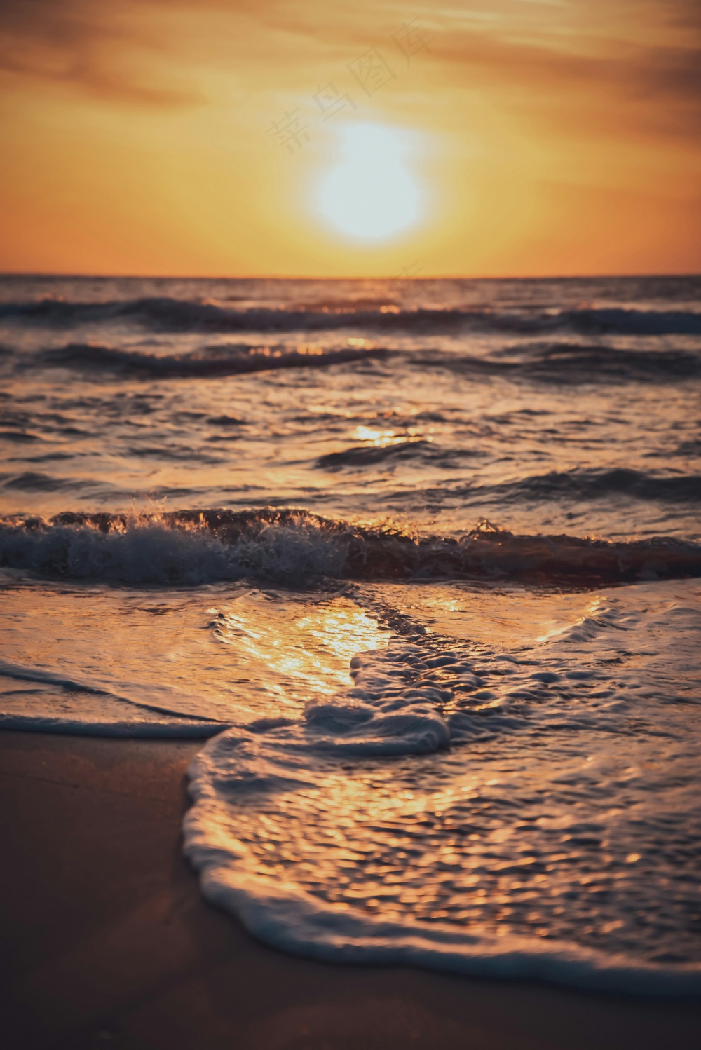 金色夕阳下的海浪轻拍沙滩