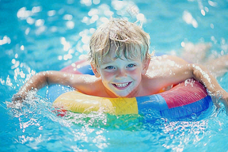 在游泳池玩水的儿童男孩游泳圈摄影图