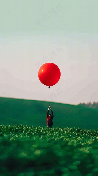 草地天空中的红色气球愚人节摄影图