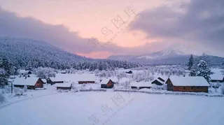 雪山下的村庄晚霞风景雪景摄影图