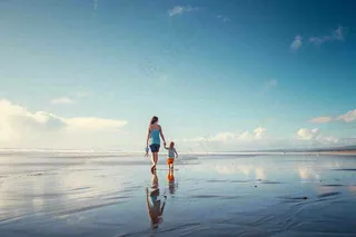 夏日海边沙滩妈妈和孩子散步母亲节温馨摄影图