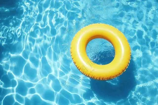 蓝色游泳池的黄色游泳圈摄影图