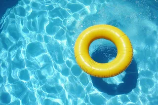 蓝色游泳池的黄色游泳圈摄影图