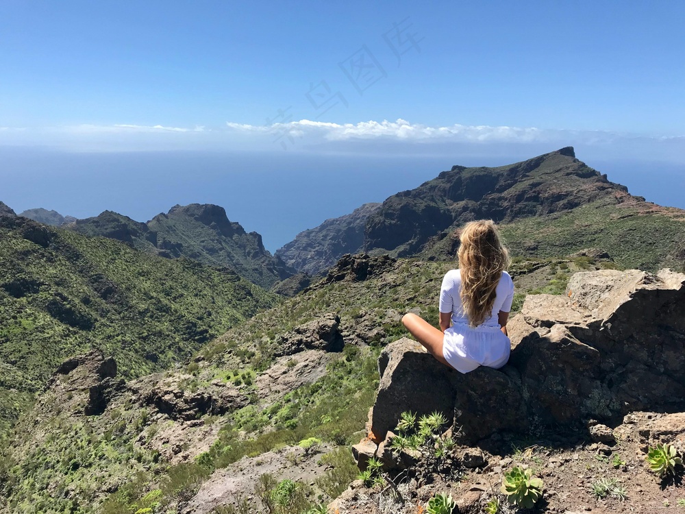 遥望群山之巅的旅者休憩