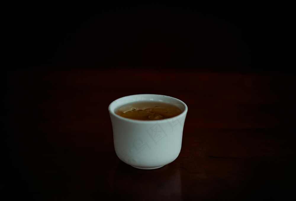 免费 黑色背景下杯茶的选择性聚焦照片 素材图片