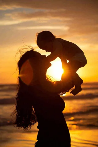 母亲节晚霞妈妈抱孩子温馨摄影图